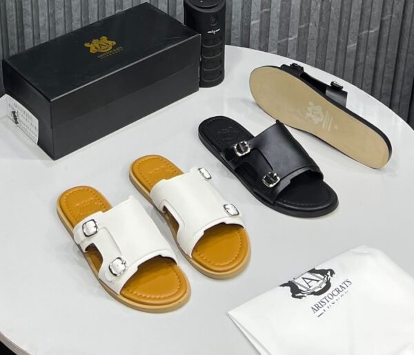 IMG-20260708-WA0043 High-quality image of luxury double strap sandals in black and white, featuring silver buckles and leather insoles, with a shoe box and dust bag.