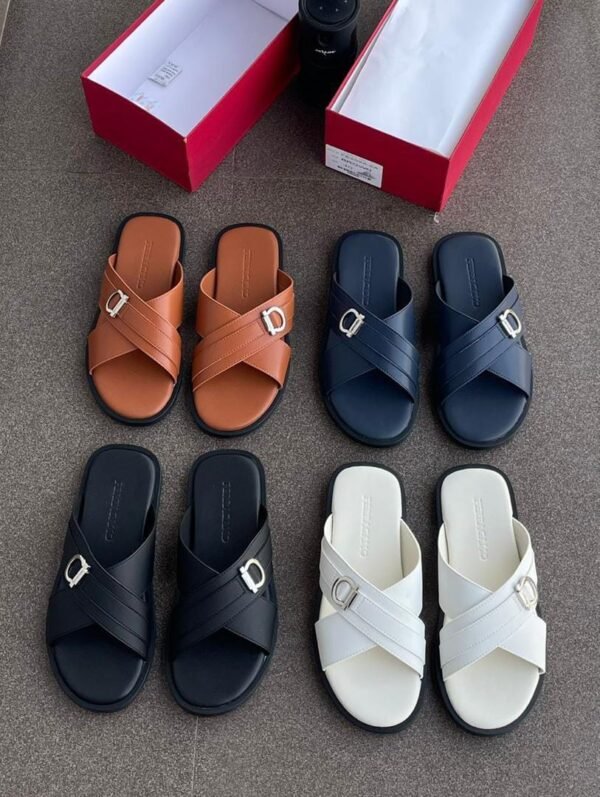A collection of stylish crisscross strap slides in brown, black, navy blue, and white, displayed with shoe boxes on a grey surface.