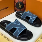 A pair of black and blue slide sandals with a Louis Vuitton-inspired design, placed in a luxury box with the Jsfootis branding.