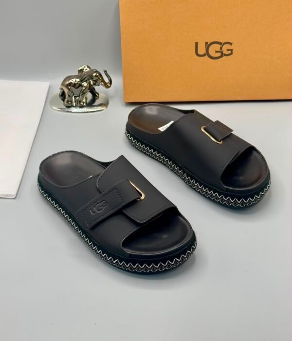 Grey UGG slide sandals with zigzag stitching and gold buckle on a white background, Jsfootis
