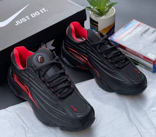 A pair of black and red Nike sport shoes with their box, perfect for those seeking a stylish and high-performance footwear option.