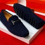 A pair of luxurious navy blue loafers with a sleek design and rubber studs on the sole, exuding sophistication and comfort, perfect for formal occasions.