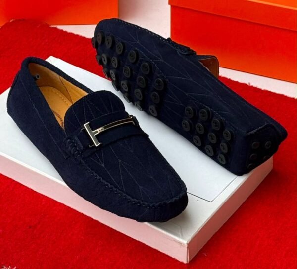 A pair of luxurious navy blue loafers with a sleek design and rubber studs on the sole, exuding sophistication and comfort, perfect for formal occasions.