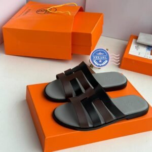 Luxurious black leather sandals on an orange shoe box, exuding high-end style and comfort, perfect for JC Luxury Footwears customers in Nigeria.