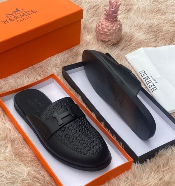 root Luxurious black leather slides with H buckle, presented in an orange Hermes box on a plush beige background, Jsfootis brings you high-end style