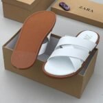 High-quality white slide sandals with brown sole, presented in an open shoe box, Jsfootis