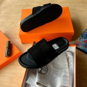 High-quality black slides in an open orange box with packaging materials, exuding luxury and comfort, Jsfootis