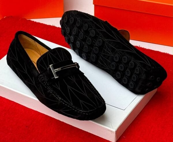 A pair of luxurious navy blue loafers with a sleek design and rubber studs on the sole, exuding sophistication and comfort, perfect for formal occasions.